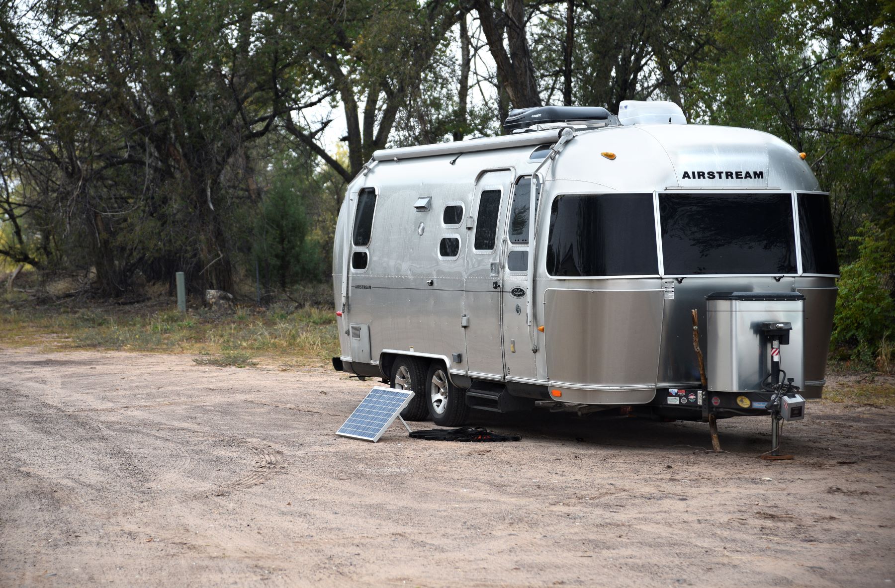 An Airstream travel trailer with solar panel kit parked in Ojo Caliente, New Mexico