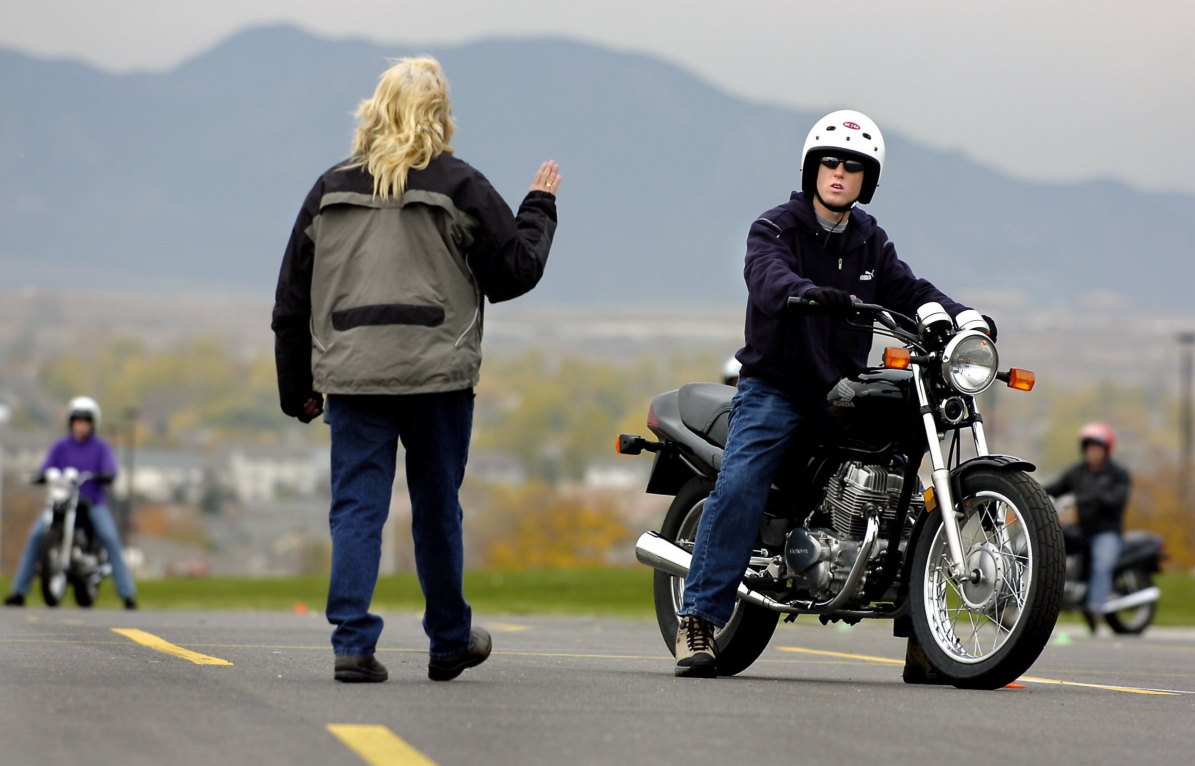 An instructor talks to a new rider at a motorcycle safety course run by A Brotherhood Active Towards Education in Colorado