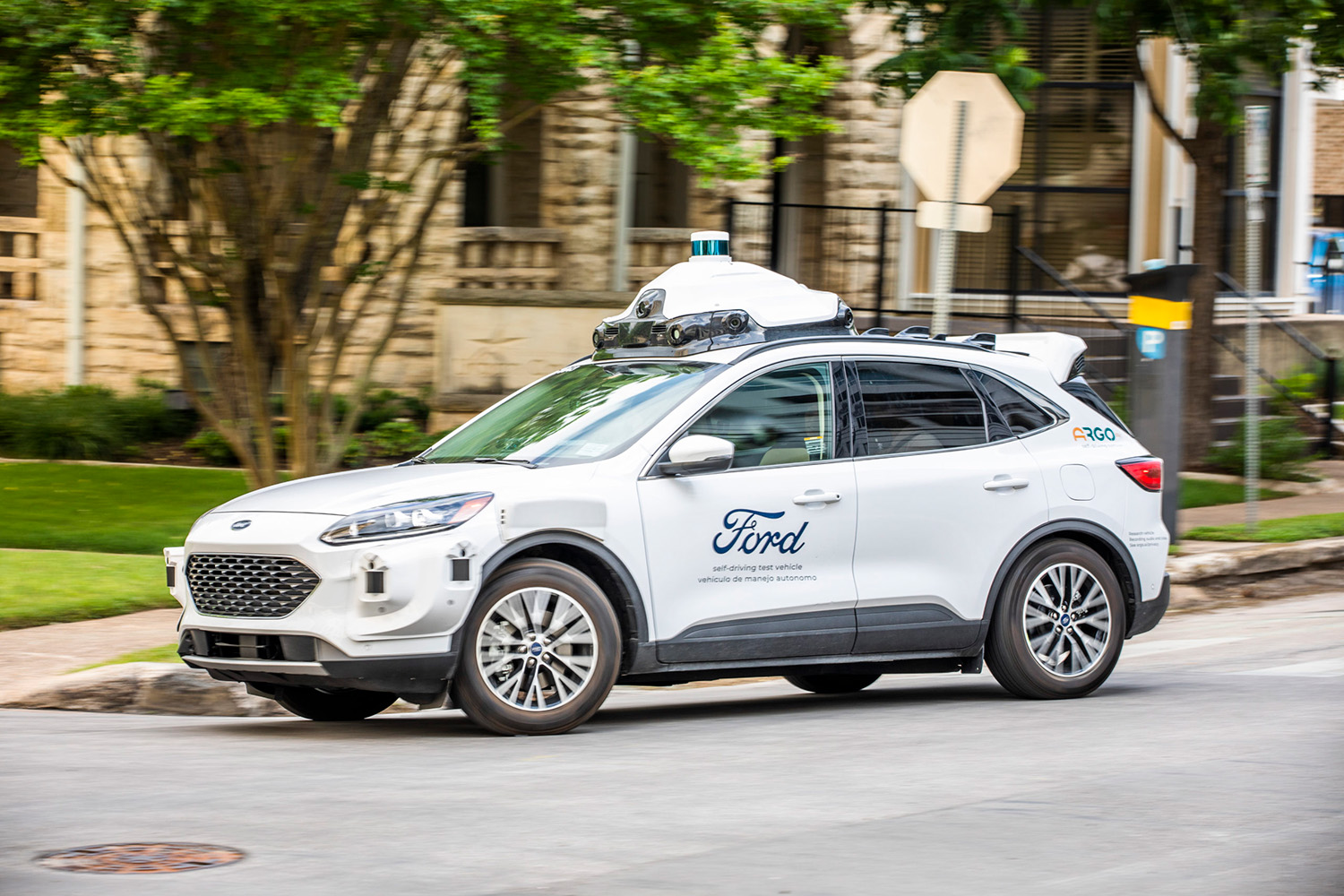 An Argo AI full self-driving taxi and delivery Ford Escape on public roads in Austin, Texas side profile