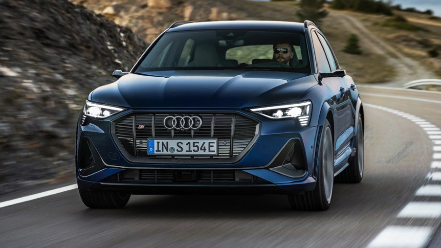 A blue 2022 Audi e-tron S is driving on the road.