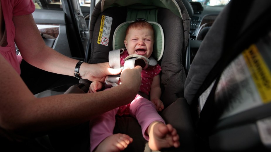 Baby crying in a child car seat, highlighting study that shows over half of child car seats have toxic chemicals