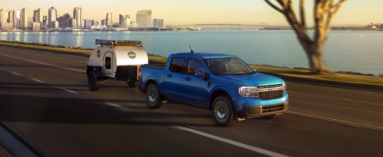 Blue 2022 Ford Maverick, the only new pickup truck that costs less than $20,000, towing a trailer