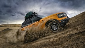 A yellow 2022 Ford Bronco Sport shows off its capability as an off-road SUV.