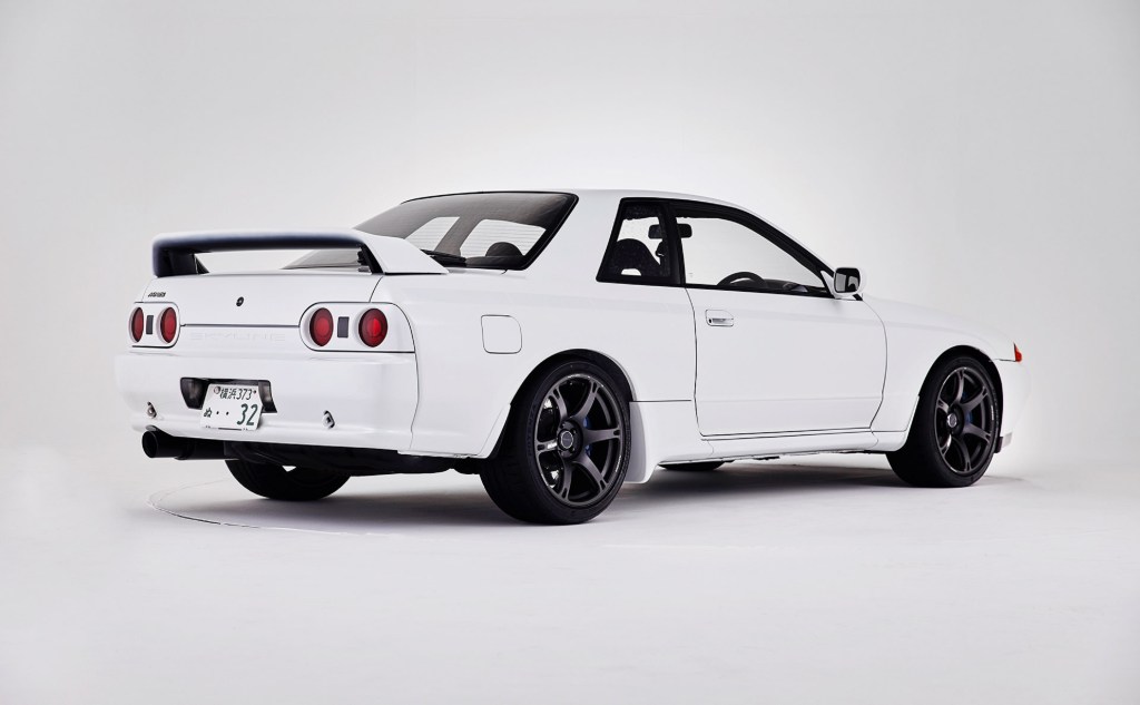 The rear 3/4 view of a white Built by Legends Mine's R32 Nissan Skyline GT-R in a white studio