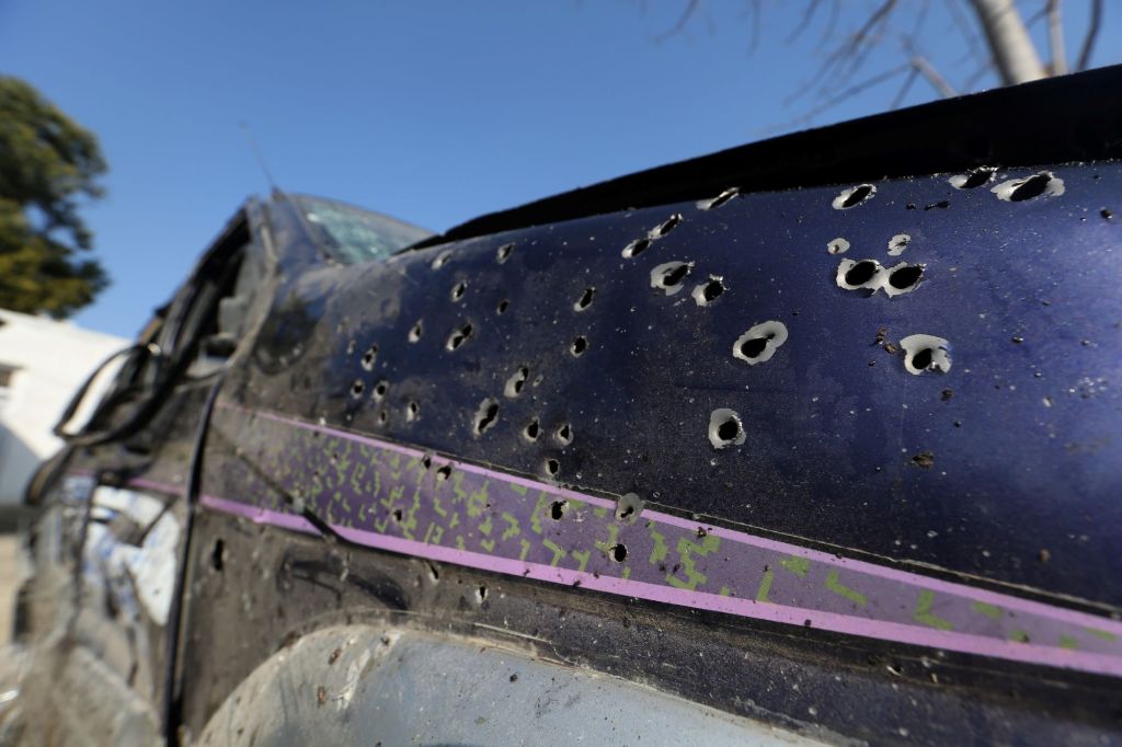 Some may seek protection from bullet holes behind a car like this one that exhibits bullet holes.