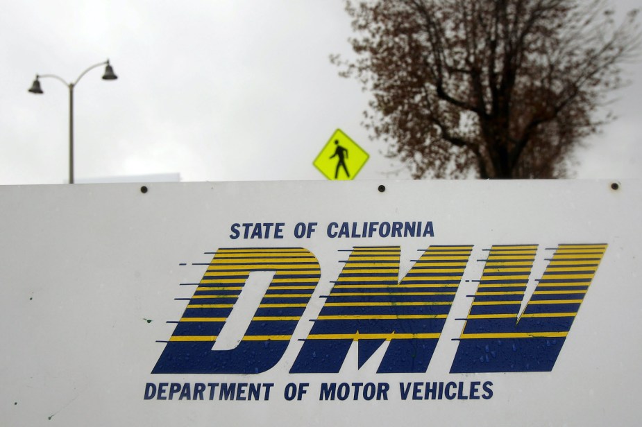 Signage is seen at the State of California Department of Motor Vehicles (DMV). it is challenging to buy a car, register it, and get insurance without a license.