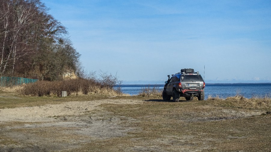 A Jeep Grand Cherokee WJ sits on a beachfront.