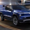 A blue 2024 Chevy Silverado EV RST blue electric pickup truck is driving.