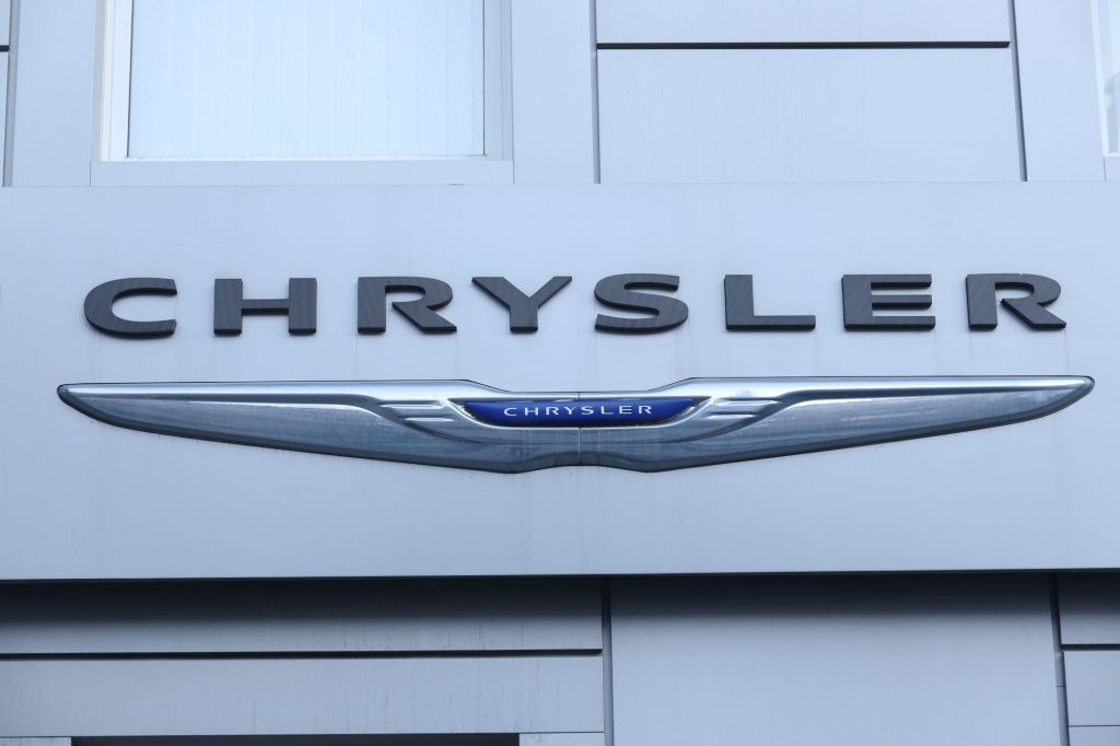 A Chrysler logo, one of the easiest cars to find during the chip shortage, on a white building. 