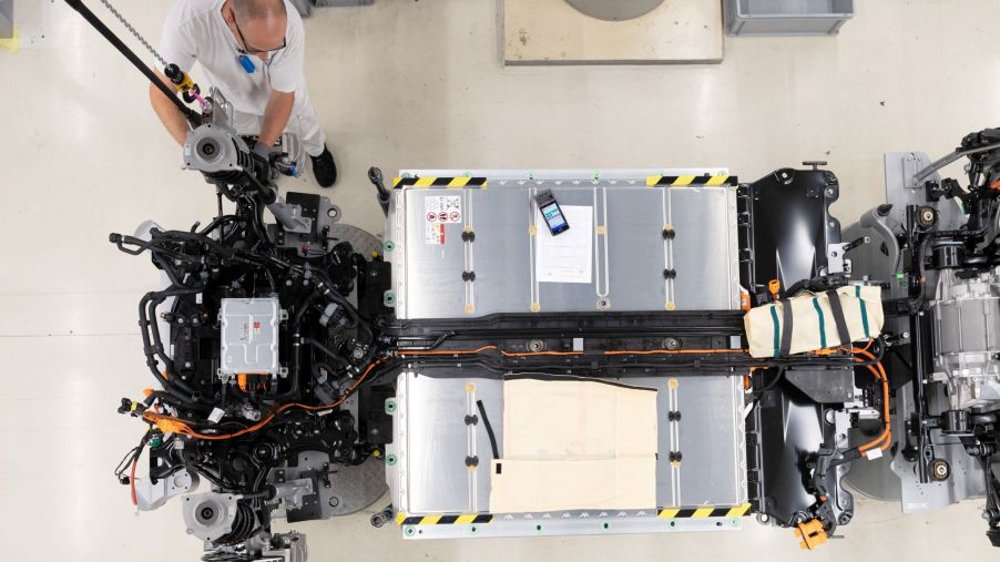 A person assembling and setting up EV batteries.