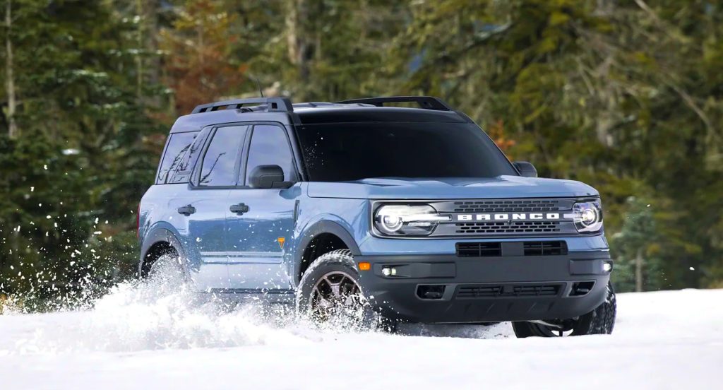 A blue 2022 Ford Bronco Sport is driving in the snow. 