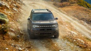 A blue 2022 Ford Bronco Sport small SUV is driving off-road.