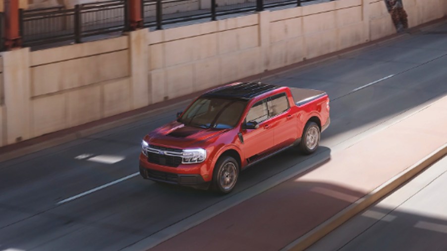 A red 2022 Ford Maverick small pickup truck is driving.