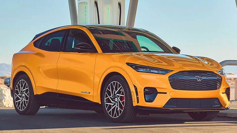 A yellow 2022 Ford Mustang Mach-E electric SUV is parked.