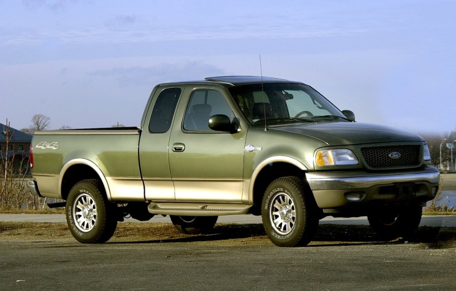 A Ford F-150 with green paint sits on a paved road, with the Triton V8 engine, it may not be reliable.