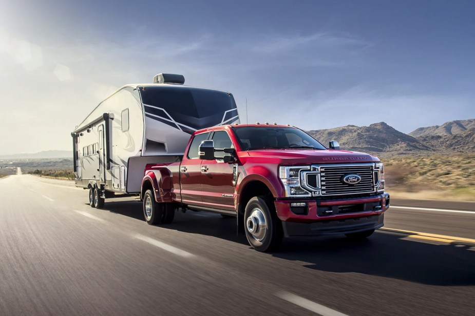 A red 2022 Ford F-350 tows a large trailer as a heavy-duty truck.