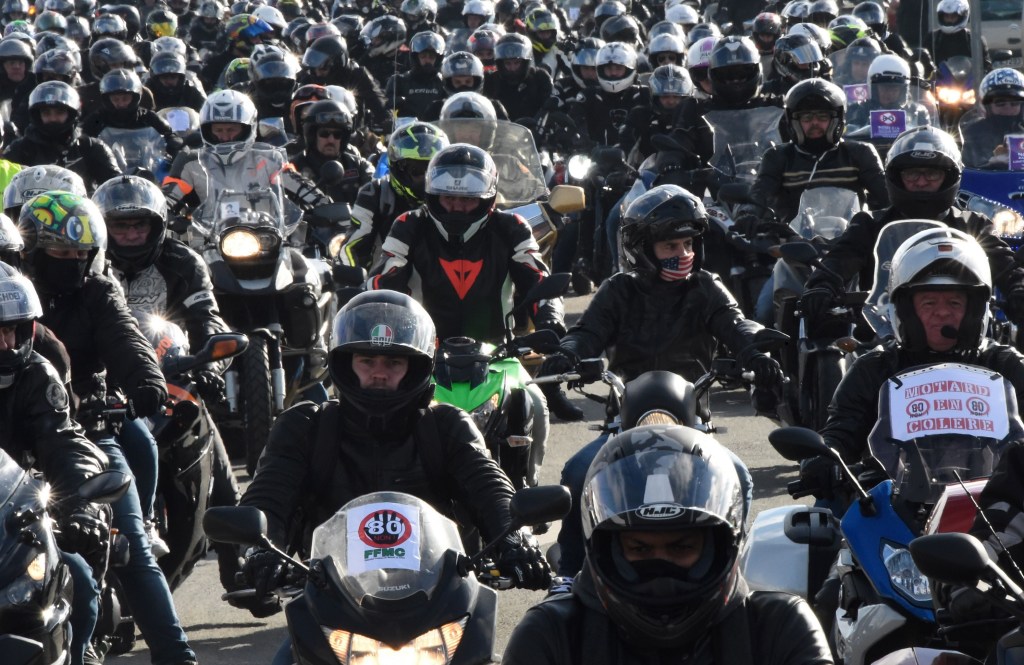 A crowd of French motorcycle riders in full safety gear riding in a protest