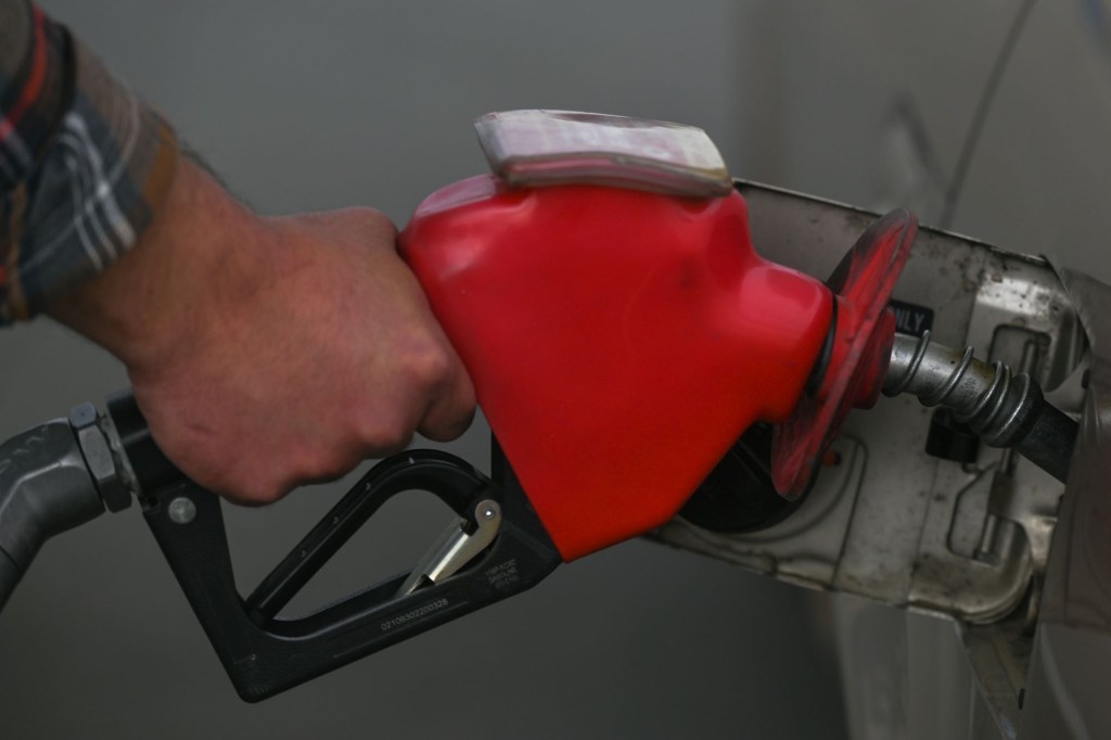 A gas pump nozzle in a car with possible additives to improve gas mileage. 