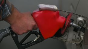A gas pump nozzle in a car with possible additives to improve gas mileage.