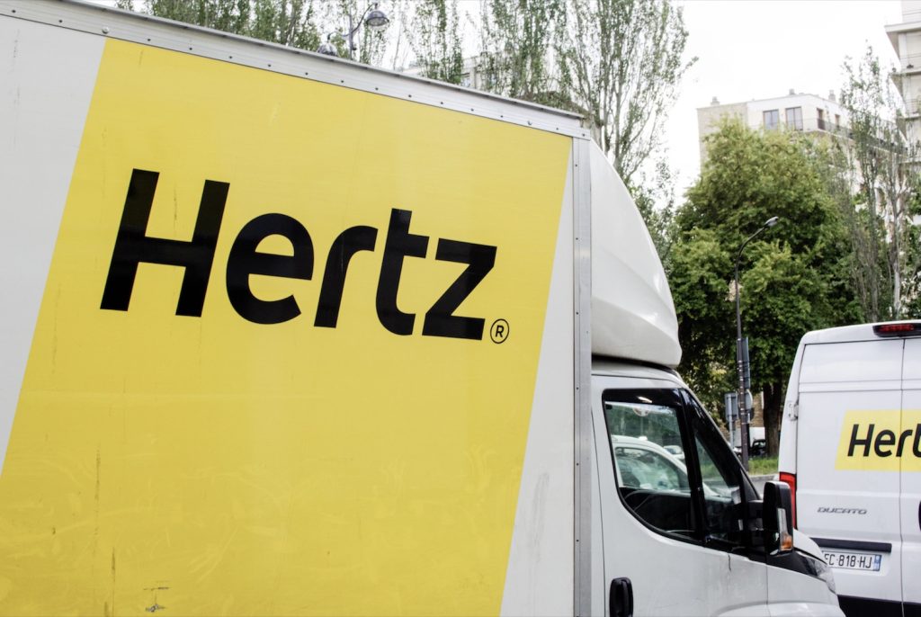 The Hertz logo on the side of a Mercedes Sprinter rental truck.