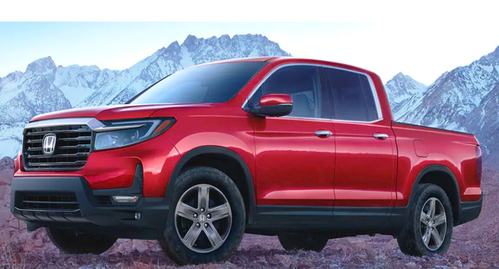 A red 2022 Honda Ridgeline compact pickup truck is parked outdoors.