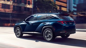 A blue 2022 Hyundai Tucson Hybrid SUV is driving.