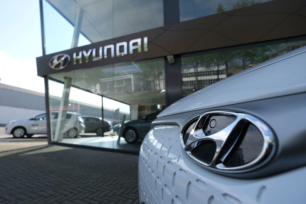The outside of a Hyundai dealership with a close up of a white Hyundai vehicle. 