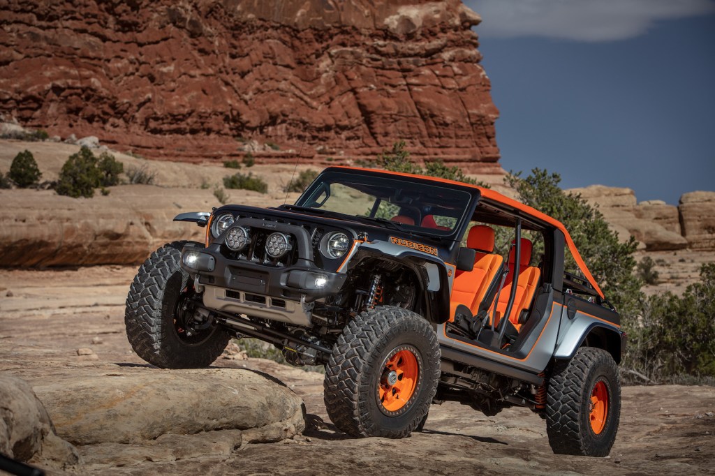 Orange and silver Jeep concept vehicle climbing a rock in Moab.