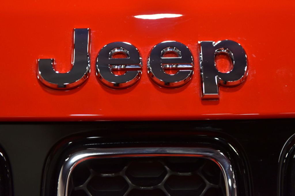 A chrome Jeep logo, maker of the 2022 Jeep Compass, on a red Jeep. 