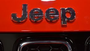 A chrome Jeep logo, maker of the 2022 Jeep Compass, on a red Jeep.