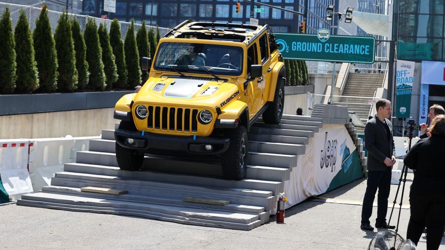 A yellow Jeep Wrangler coming down an incline.