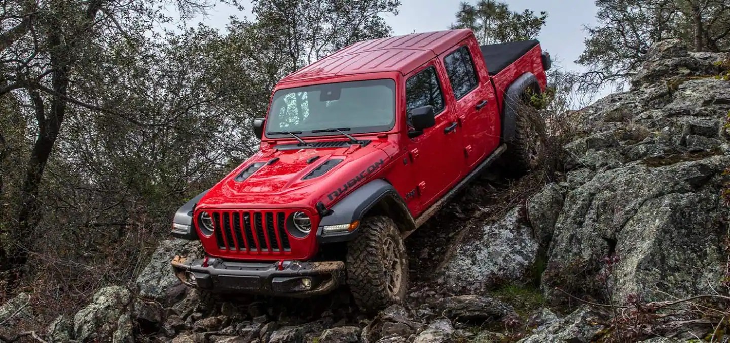 A Jeep Gladiator uses locking differentials to navigate off-road terrain. It has a standard V6 engine.