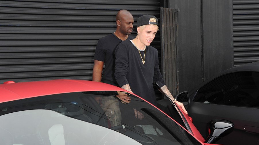 Justin Bieber getting into the driver seat of his matte red Ferrari 458 at West Coast Customs in LA