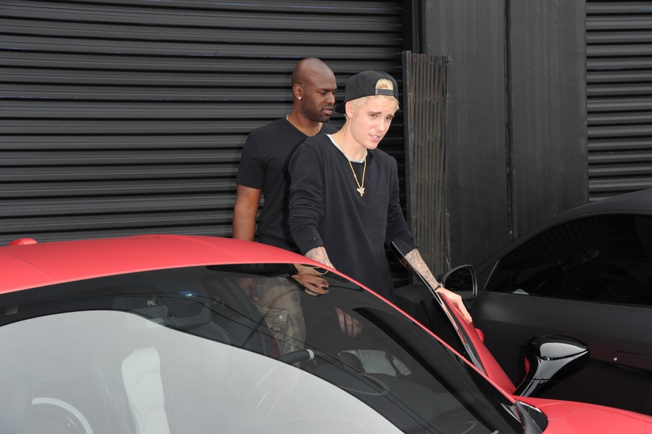 Justin Bieber getting into the driver seat of his matte red Ferrari 458 at West Coast Customs in LA