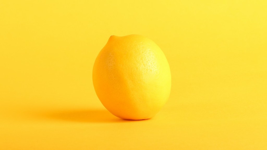 a lemon against a yellow background, which is another term for a used car that has lots of problems