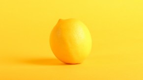 a lemon, another term for an unreliable car, against a yellow background