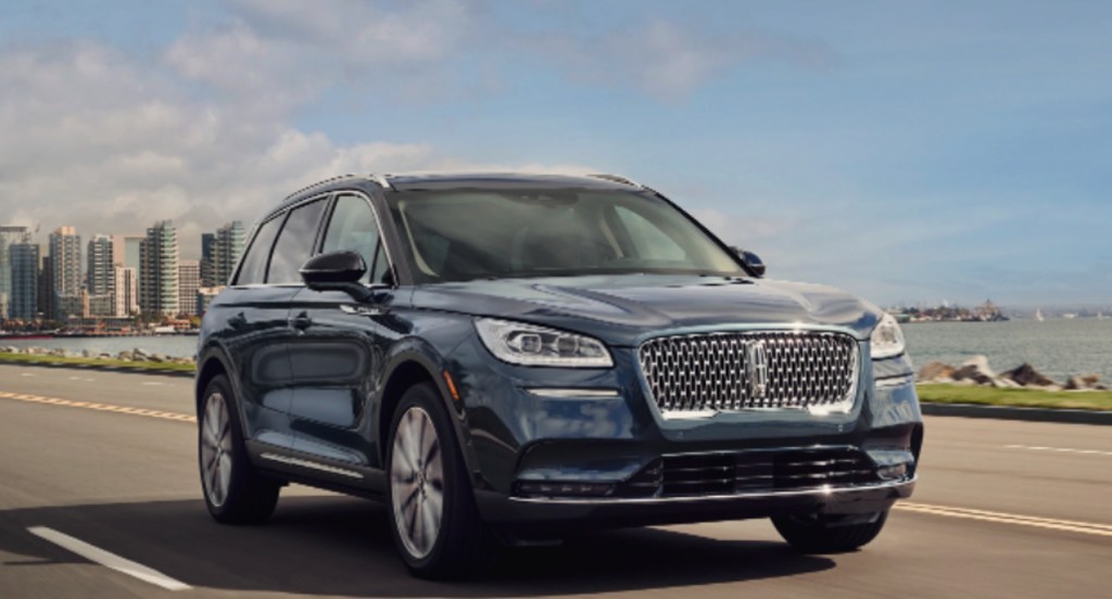 A blue 2022 Lincoln Corsair luxury SUV is driving on the road. 