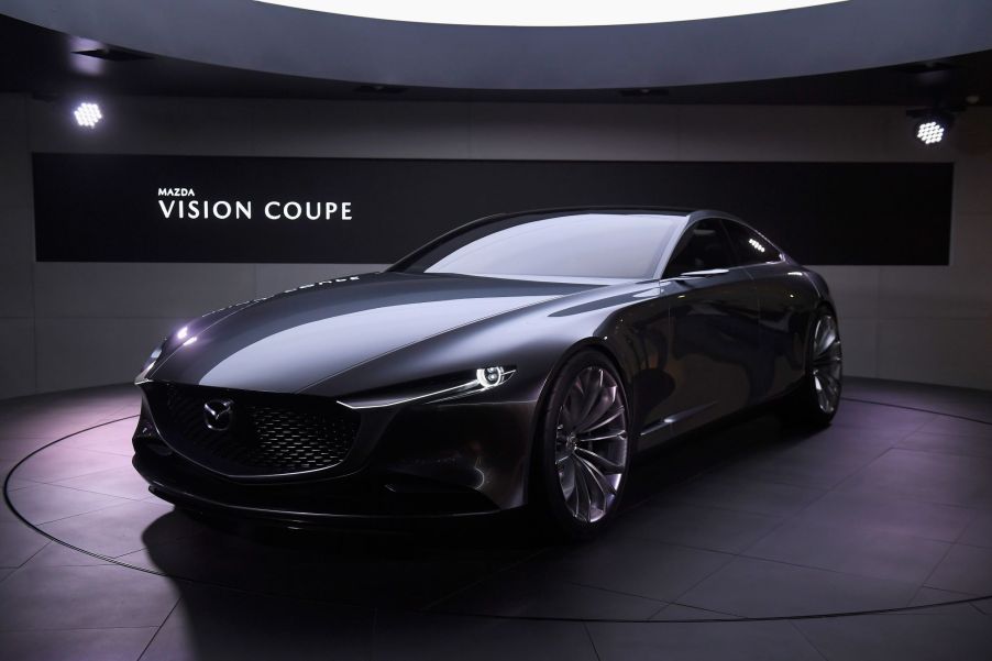 A gun metal gray Mazda Vision concept car in an indoor environment.