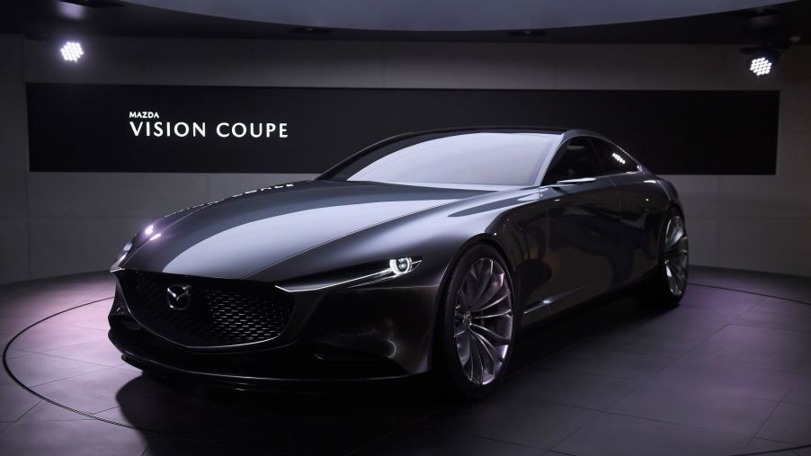 A gun metal gray Mazda Vision concept car in an indoor environment.