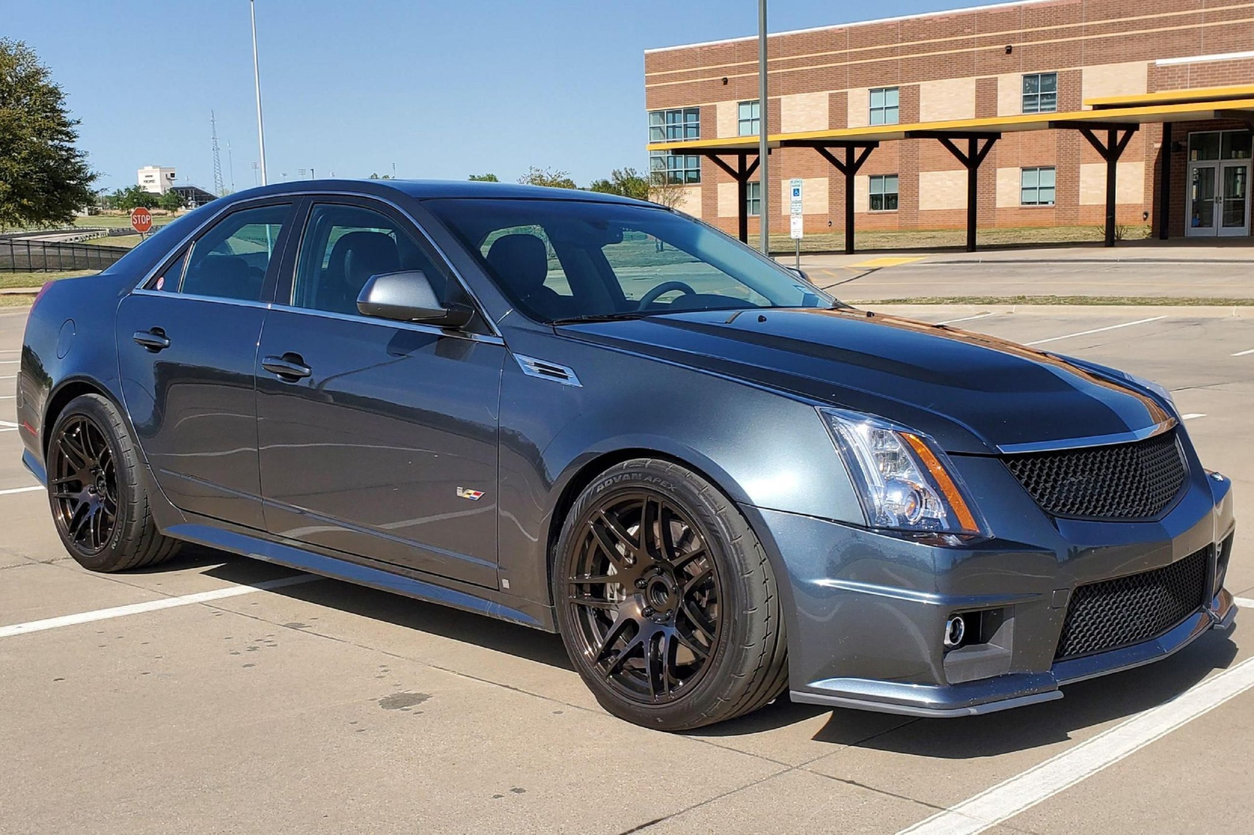 A modified gray 2009 Cadillac CTS-V Sedan in a school parking lot