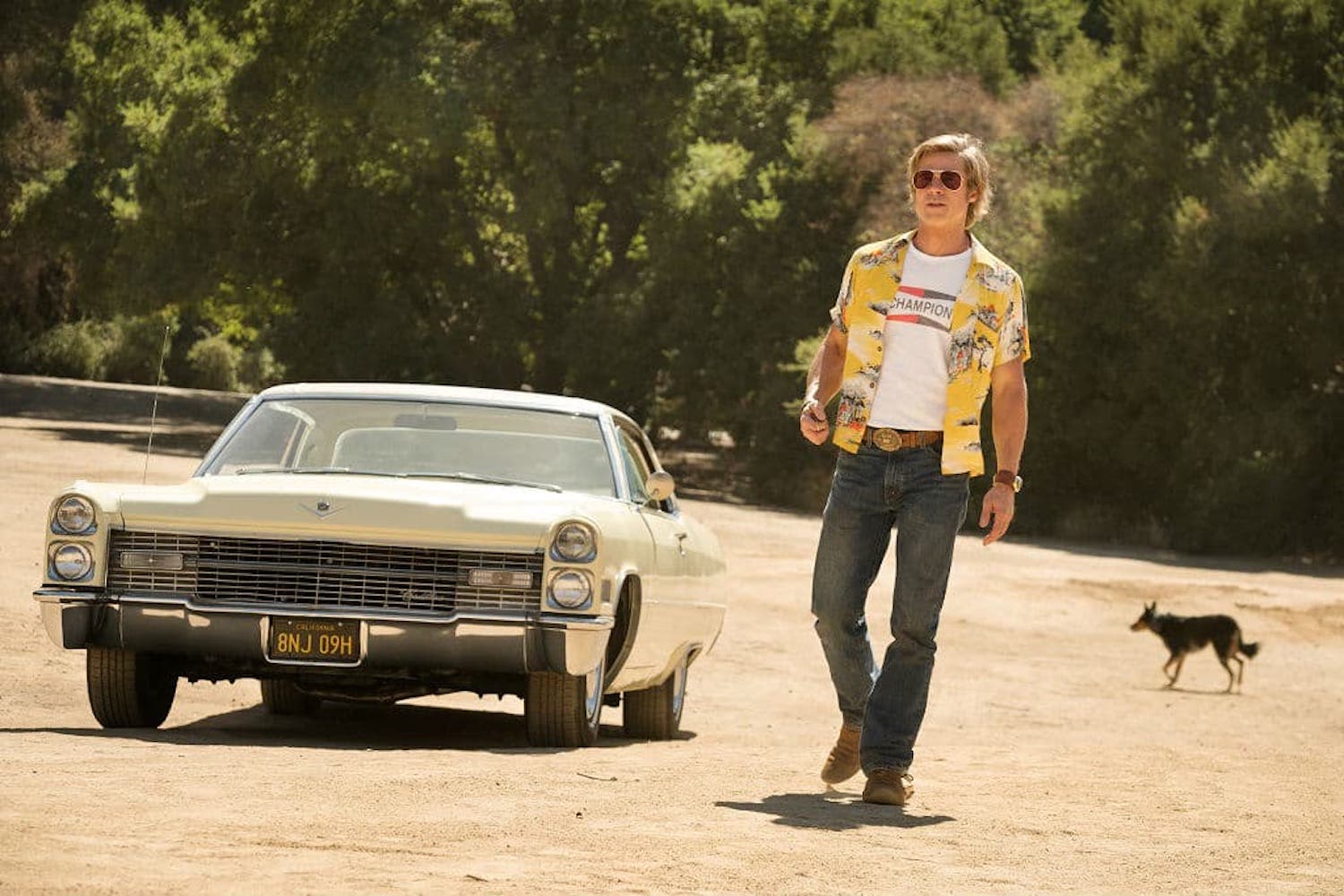 Brad Pitt's Cliff Booth walking away from DiCaprio's 1966 Cadillac Coupe DeVille in a scene from Once Upon a Time in Hollywood