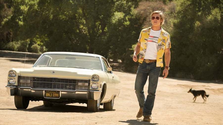Brad Pitt's Cliff Booth walking away from DiCaprio's 1966 Cadillac Coupe DeVille in a scene from Once Upon a Time in Hollywood