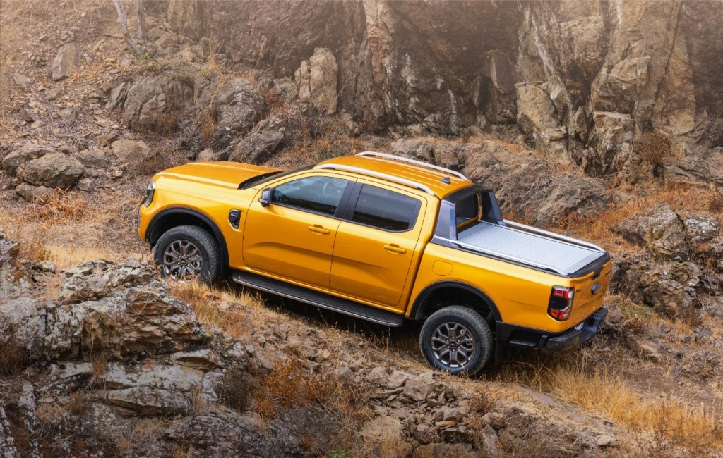 Orange 2023 Ford Ranger driving on a mountain road, highlighting how Ford Ranger EV could be the best electric truck
