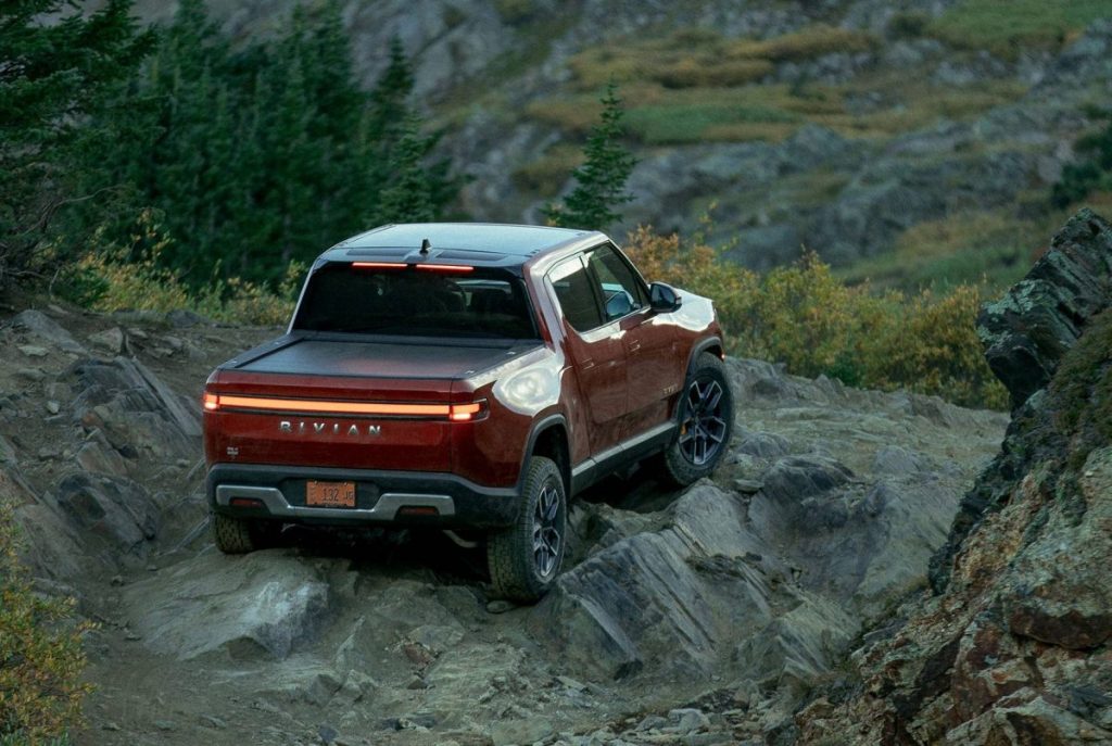 Rear view of and orange-red 2022 Rivian R1T, the first production electric pick up truck.