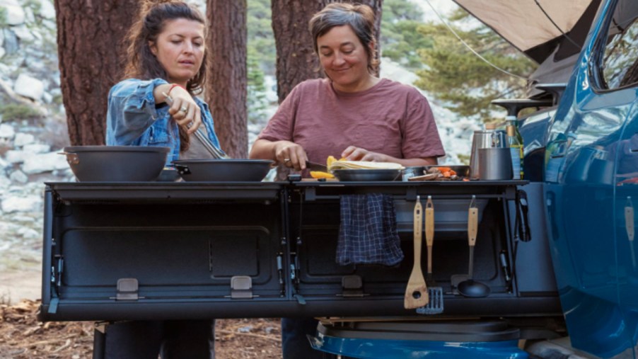 People are cooking using the 2022 Rivian R1T camp kitchen.