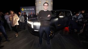 Rivian's CEO, known to have commented on the battery shortage, standing in front of a Rivian pickup truck.
