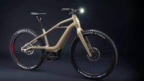 A tan Serial 1 BASH/MTN electric mountain bike in a black studio