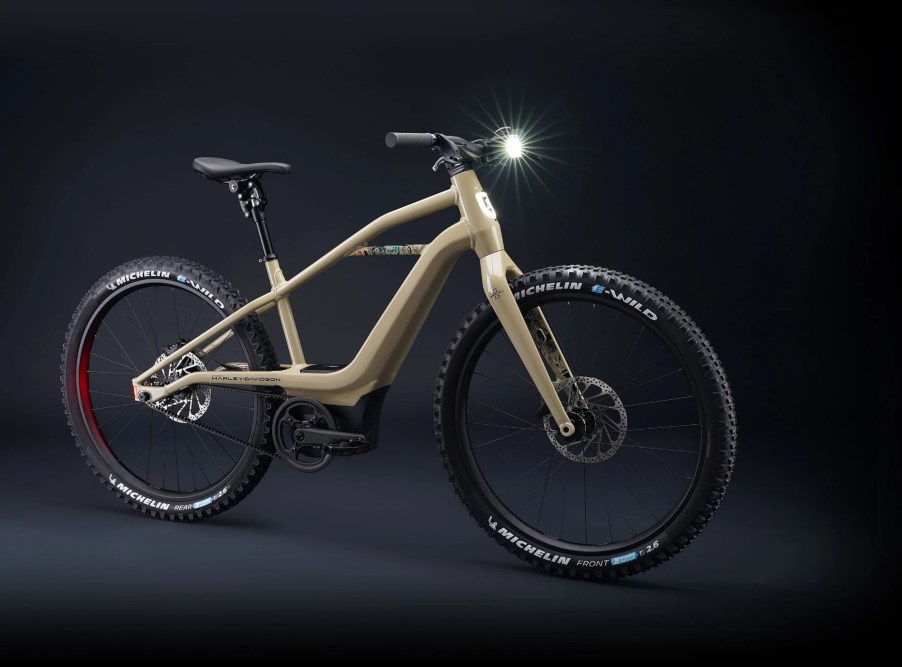 A tan Serial 1 BASH/MTN electric mountain bike in a black studio