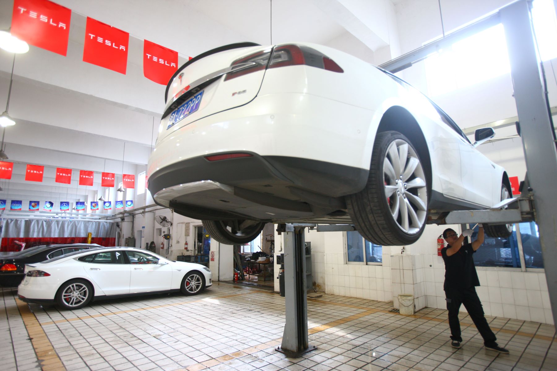 Tesla automotive car service being performed by a maintenance technician in Ningo, Zhejiang, China