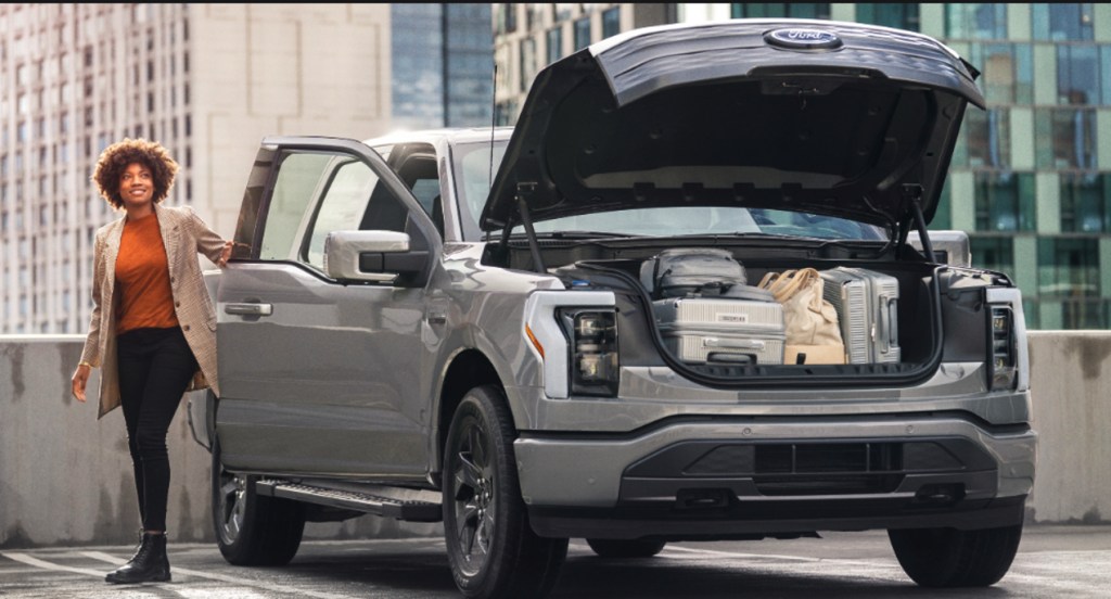 A gray 2022 Ford F-150 Lightning electric pickup truck is parked with its frunk open. 